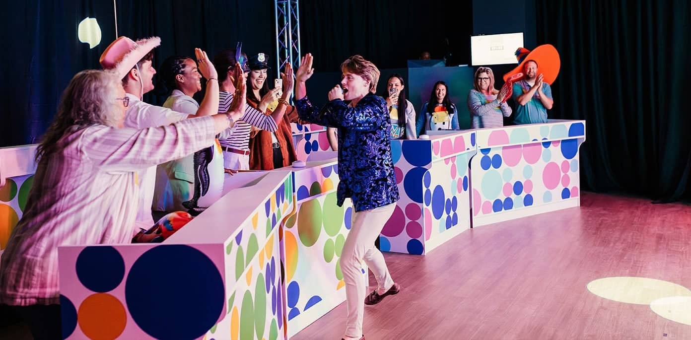 game show host high fiving the participants