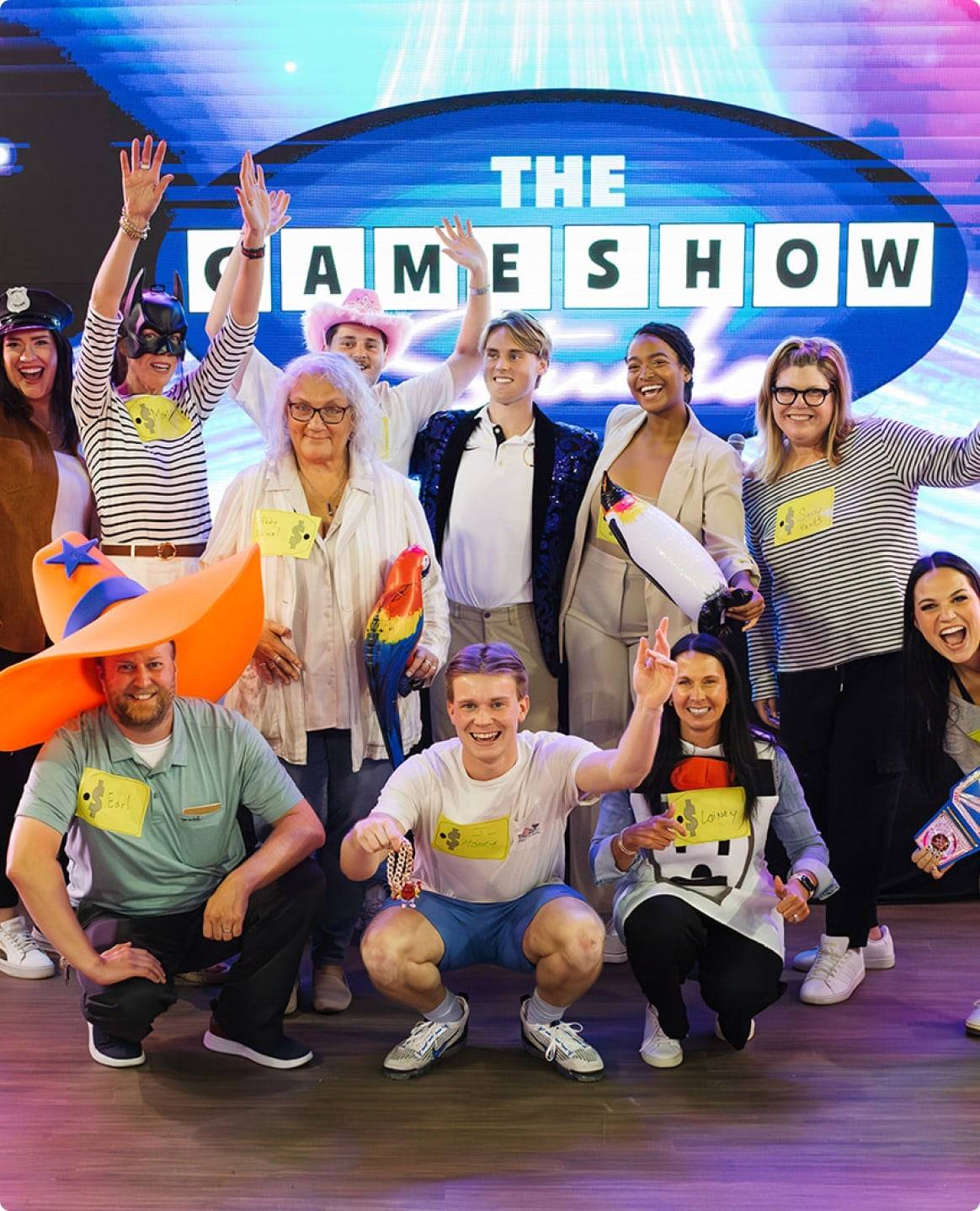 Game show host and contestants smiling for portrait