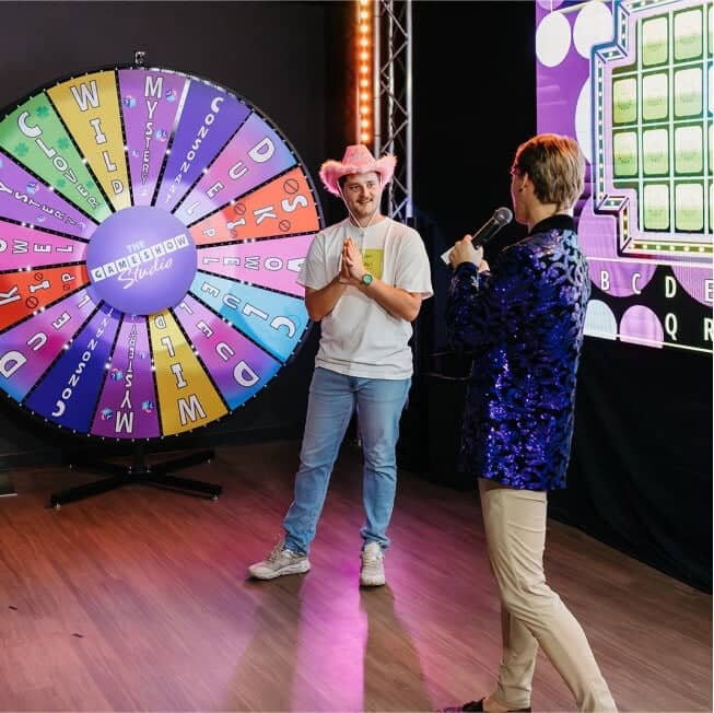 contestant wearing cowgirl hat with game show host