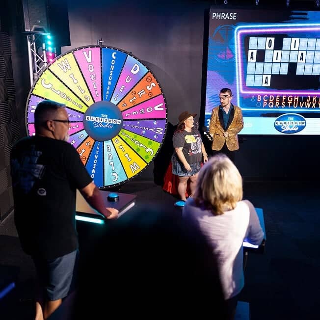 game show participant next to spin wheel with host