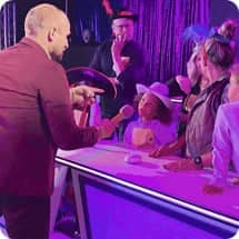 game show studio host asking kid contestants a question