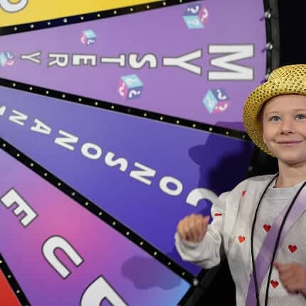 kid in front of game show wheel