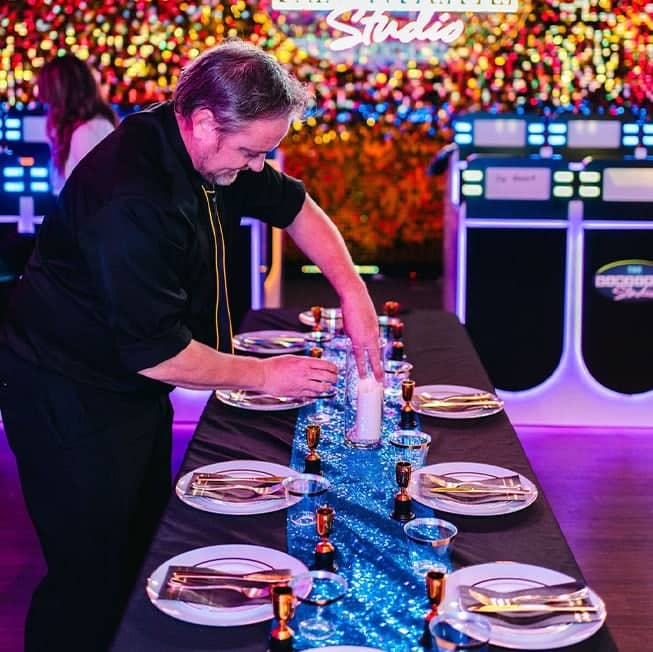 man setting up dining tables for private company event