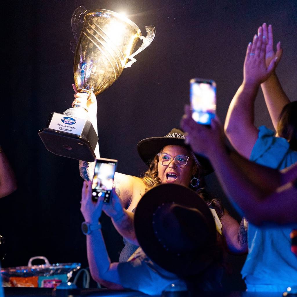 Birthday guest holding up a trophy at The Game Show Studio