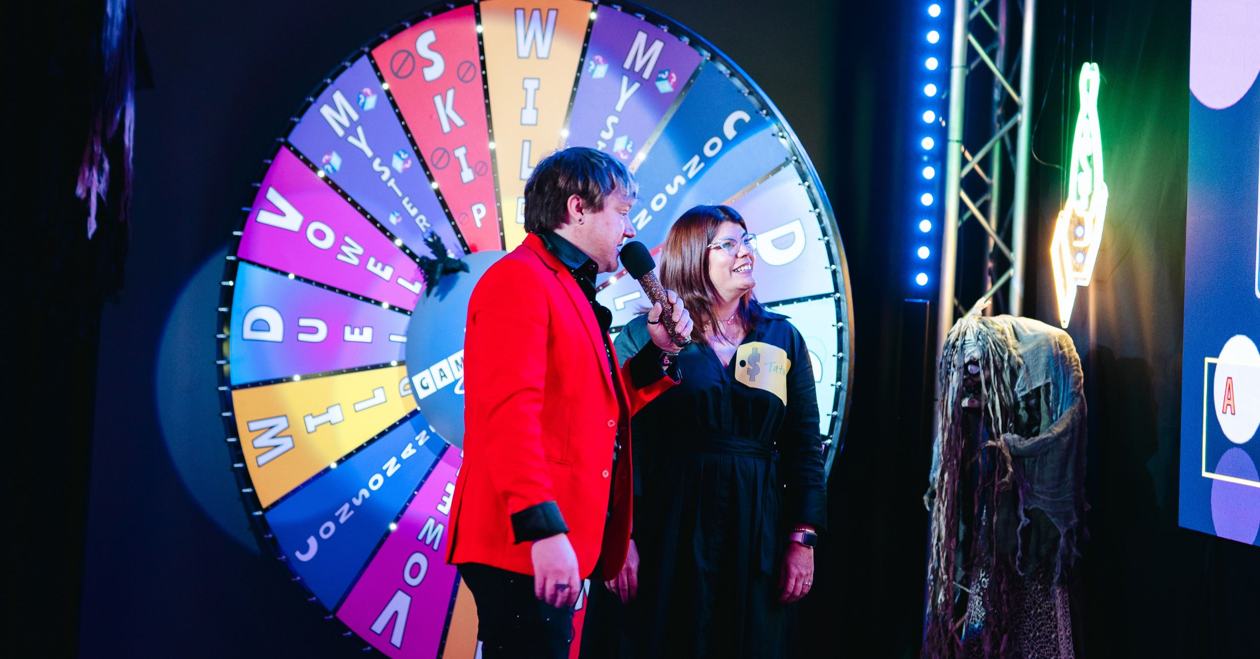 player and host standing in front of wheel