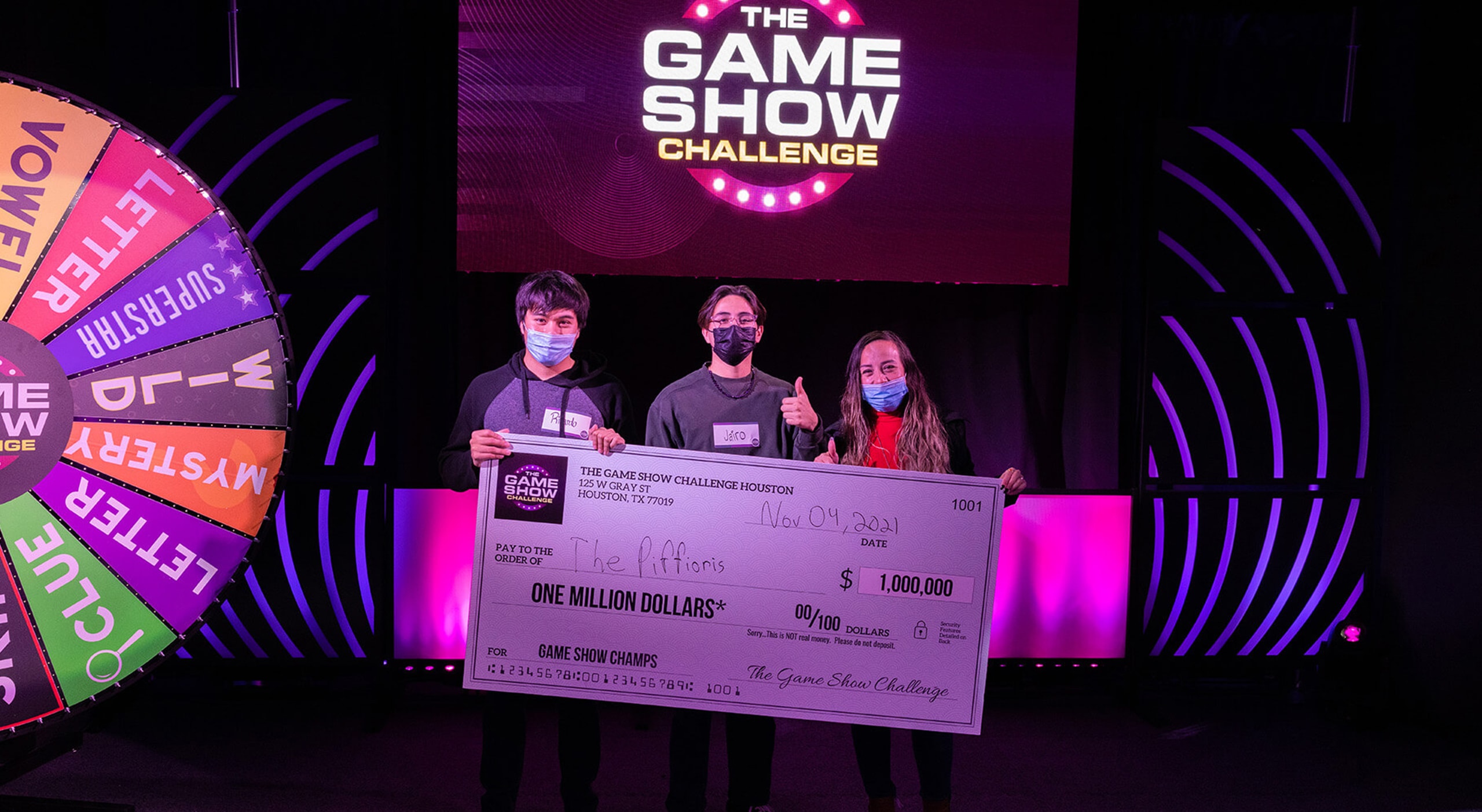 winners holding check from game show studio
