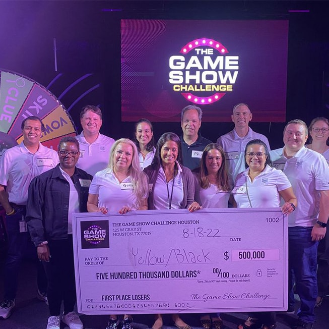 work employees holding check from winning the game show challenge