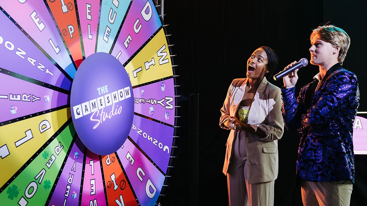 woman spinning wheel of fortune with host
